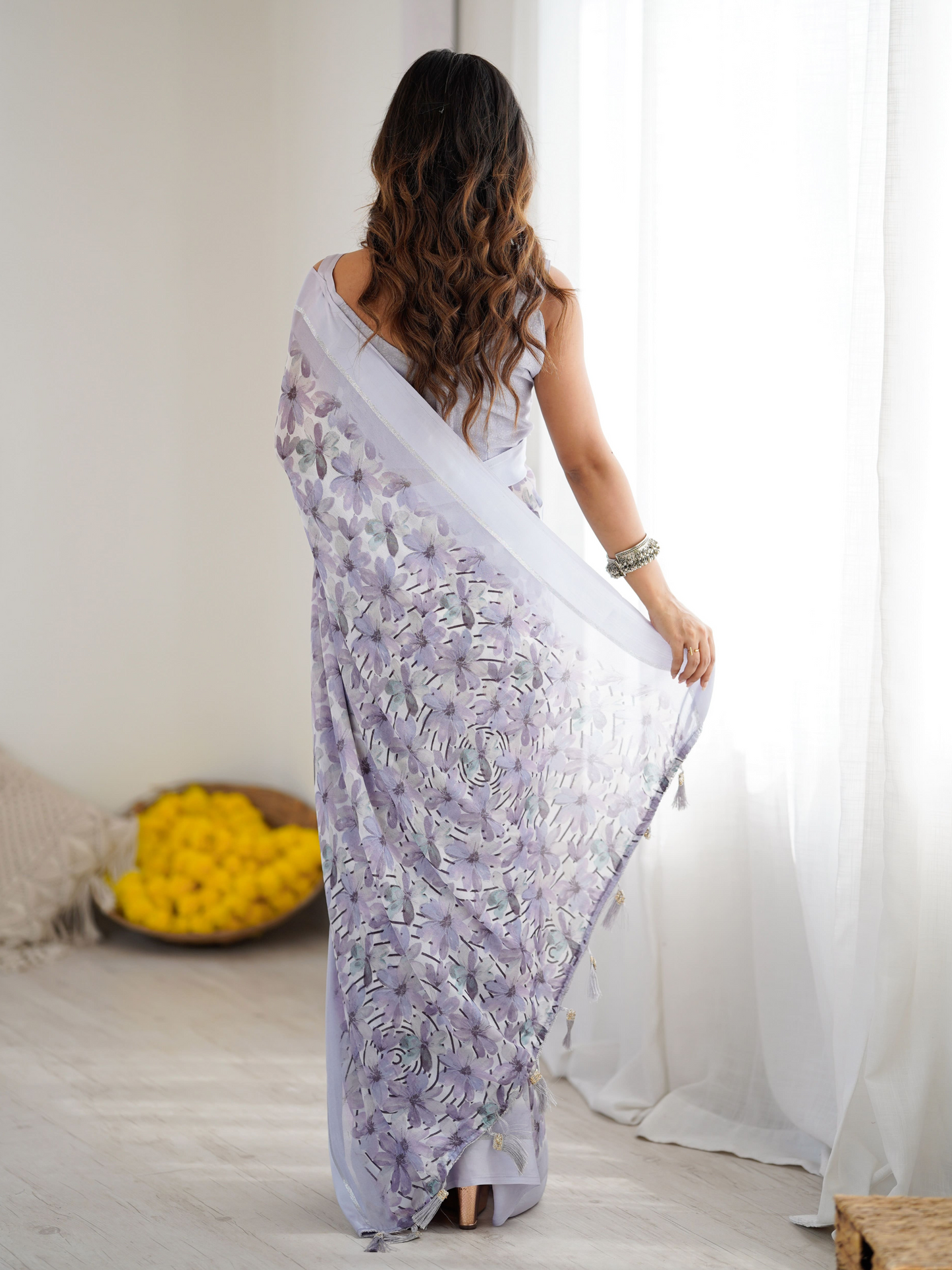 Woman in a white saree with floral patterns