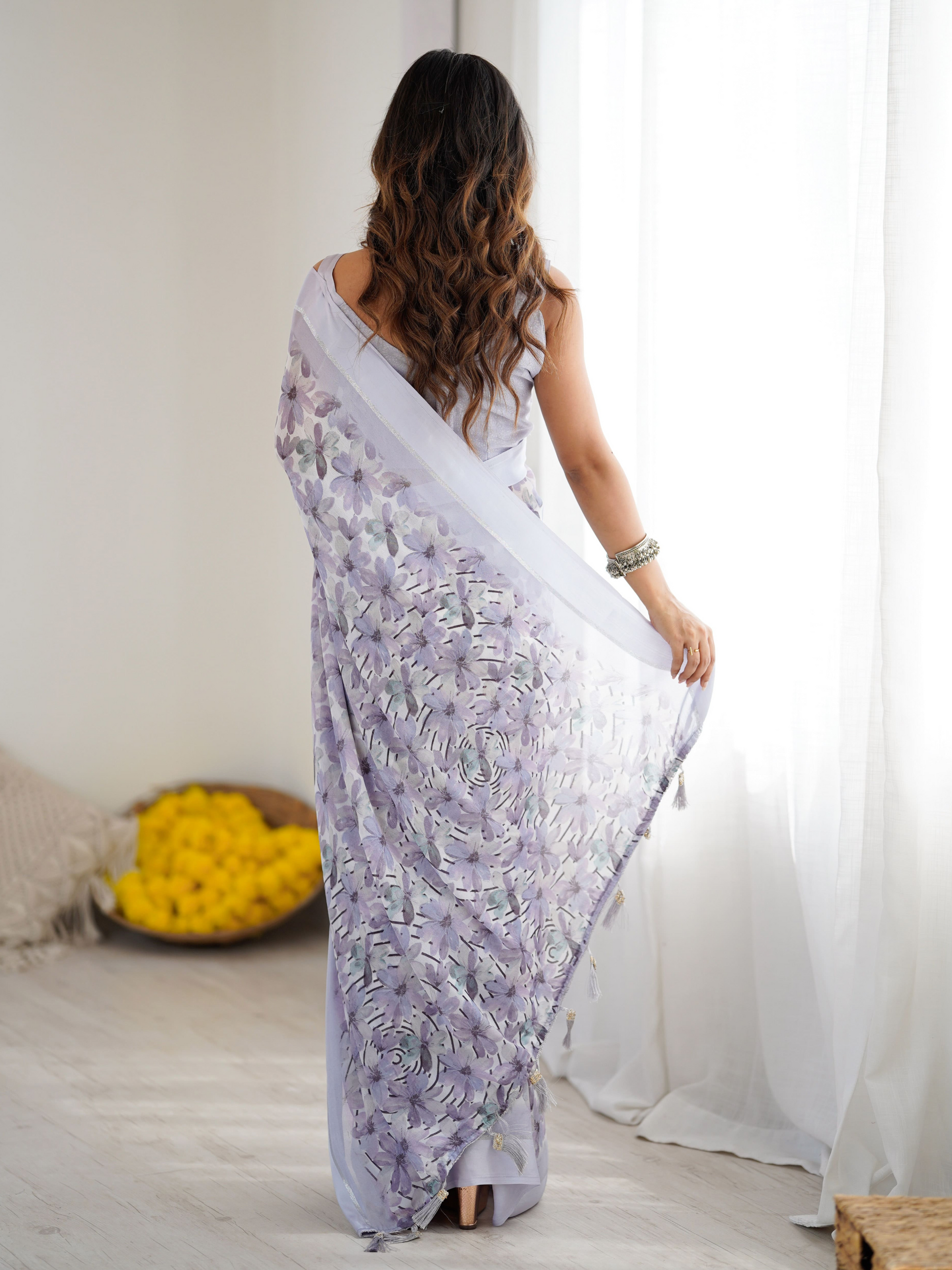 Woman in a white saree with floral patterns