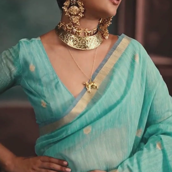 woman in sky color saree with golden jewellery