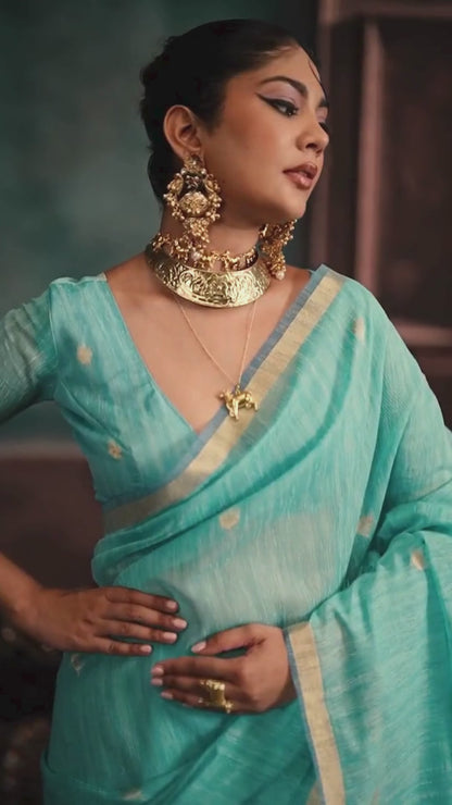 woman in sky color saree with golden jewellery