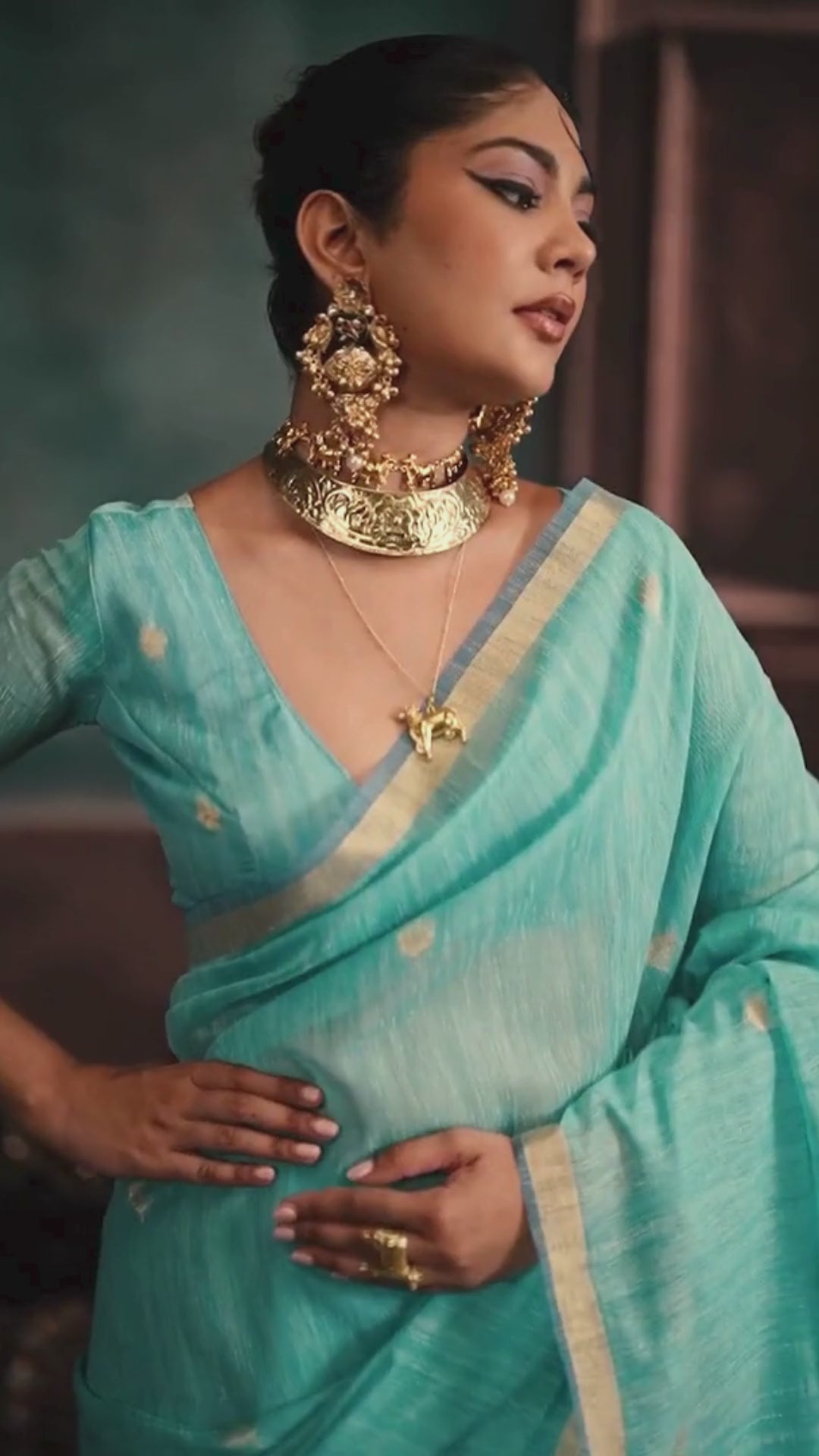woman in sky color saree with golden jewellery